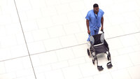 Bildet viser sykepleier som triller en tom rullestol