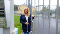 bildet viser Bente Sundbye ved den låste porten utenfor sikkerhetsavdelingen på Dikemark