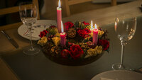 Bildet viser et middagsbord som er pyntet med julelys og blomster
