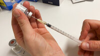 Bildet viser en sprøyte med covid-19-vaksine som blir trukket opp.