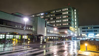 Bildet viser Stavanger universitetssjukehus (SUS) fra veistubben inn mot hovedinngangen i mørket.