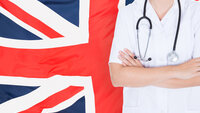 Bildet viser et britisk flagg i bakgrunnen og overkroppen til en person i hvit uniform