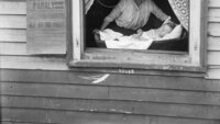 Bildet viser kvinne og barn i et vindu under polioepidemien i USA i 1916.