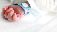 Bildet viser hånden til en nyfødt baby.