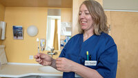Bildet viser Lisa Hugdahl som holder en injeksjonssprøyte påsatt et forstøverforstykke.