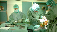 Operasjonssykepleier og kirurger/leger i arbeid.
