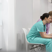 Sykepleier og pasient i sykehuskorridor